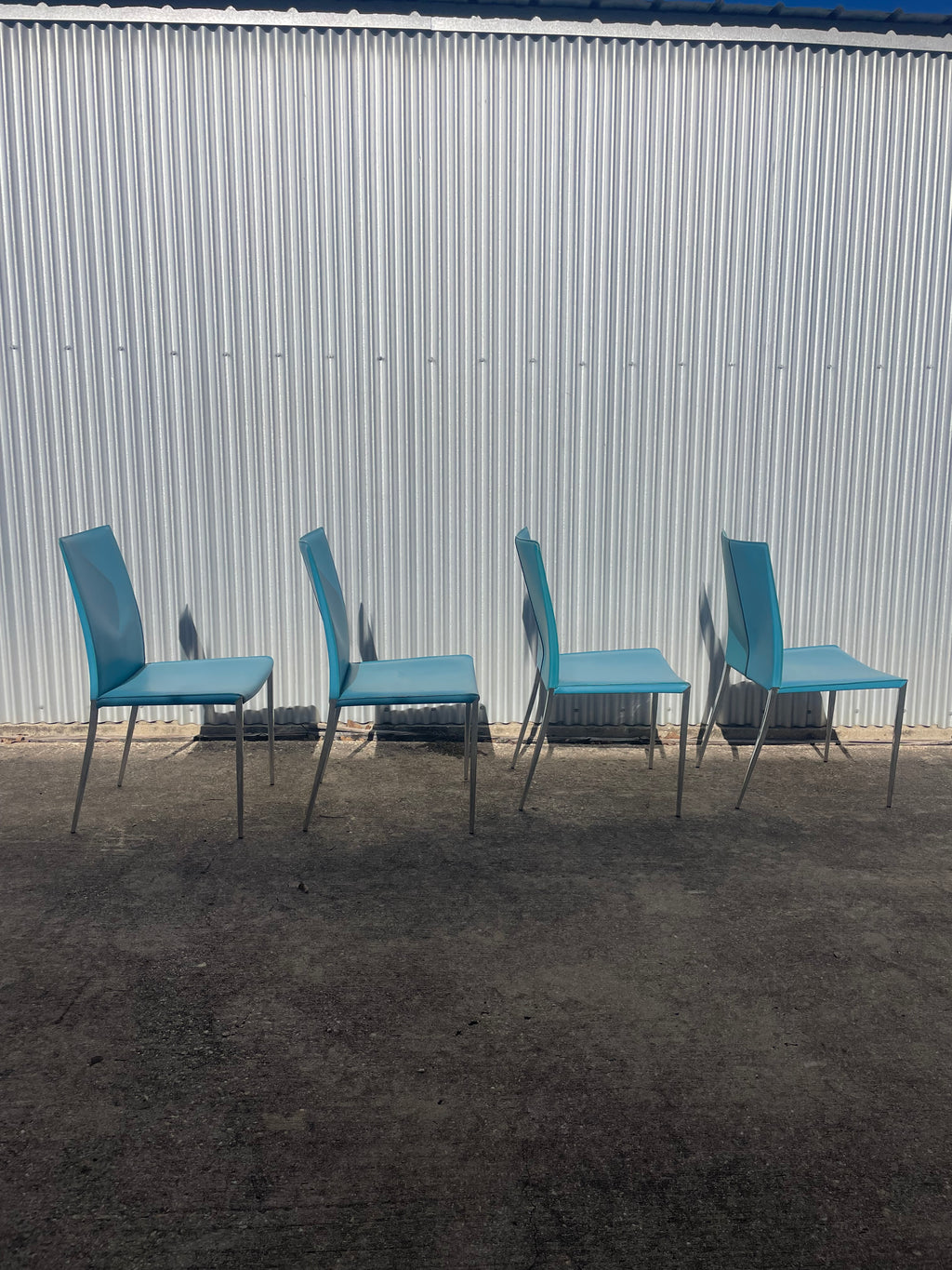 set of four teal leather dining chairs