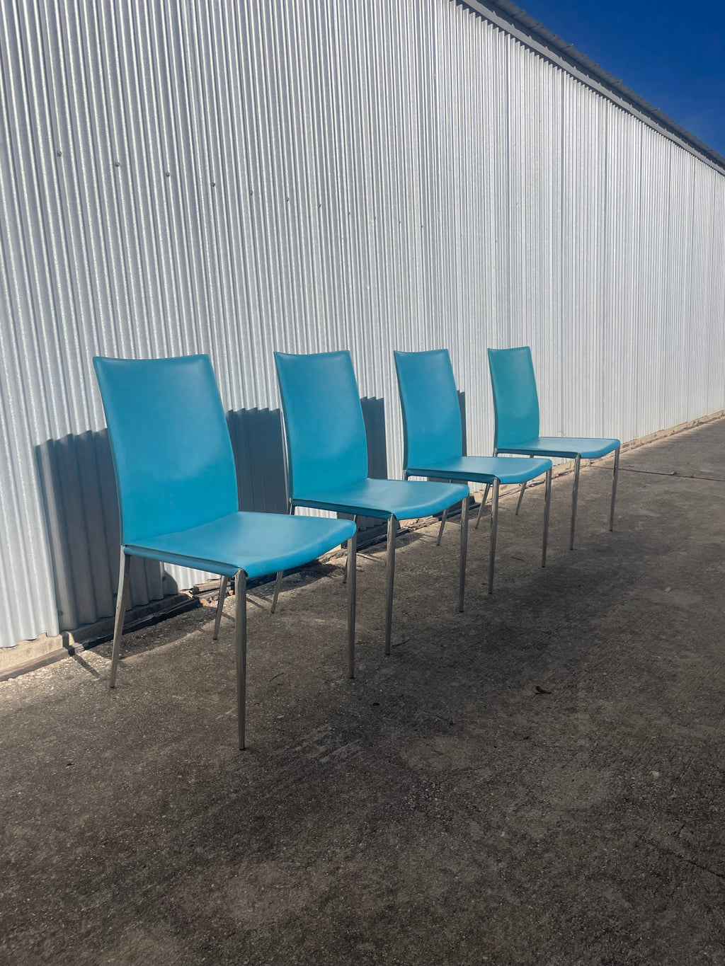 set of four teal leather dining chairs