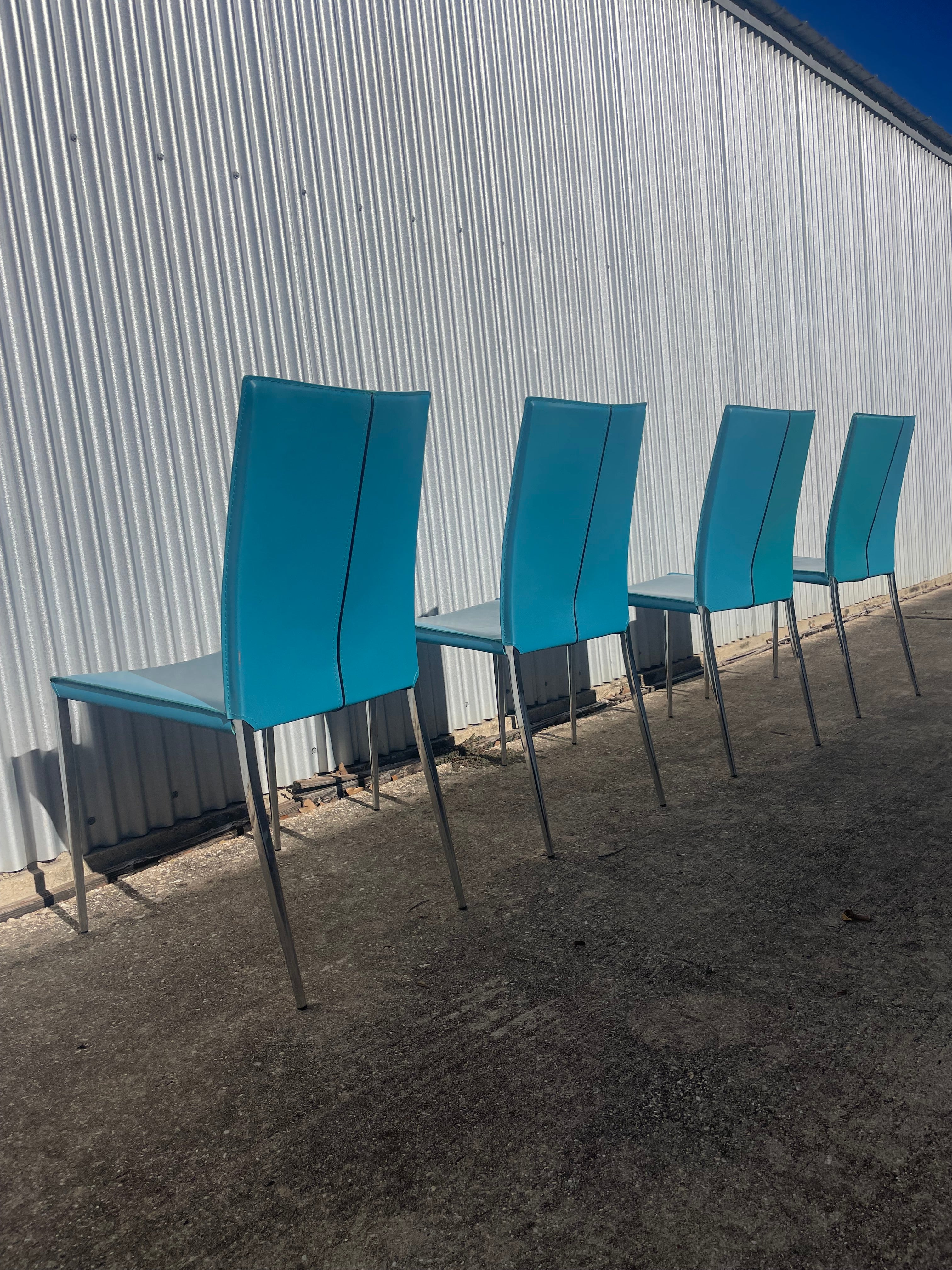 set of four teal leather dining chairs