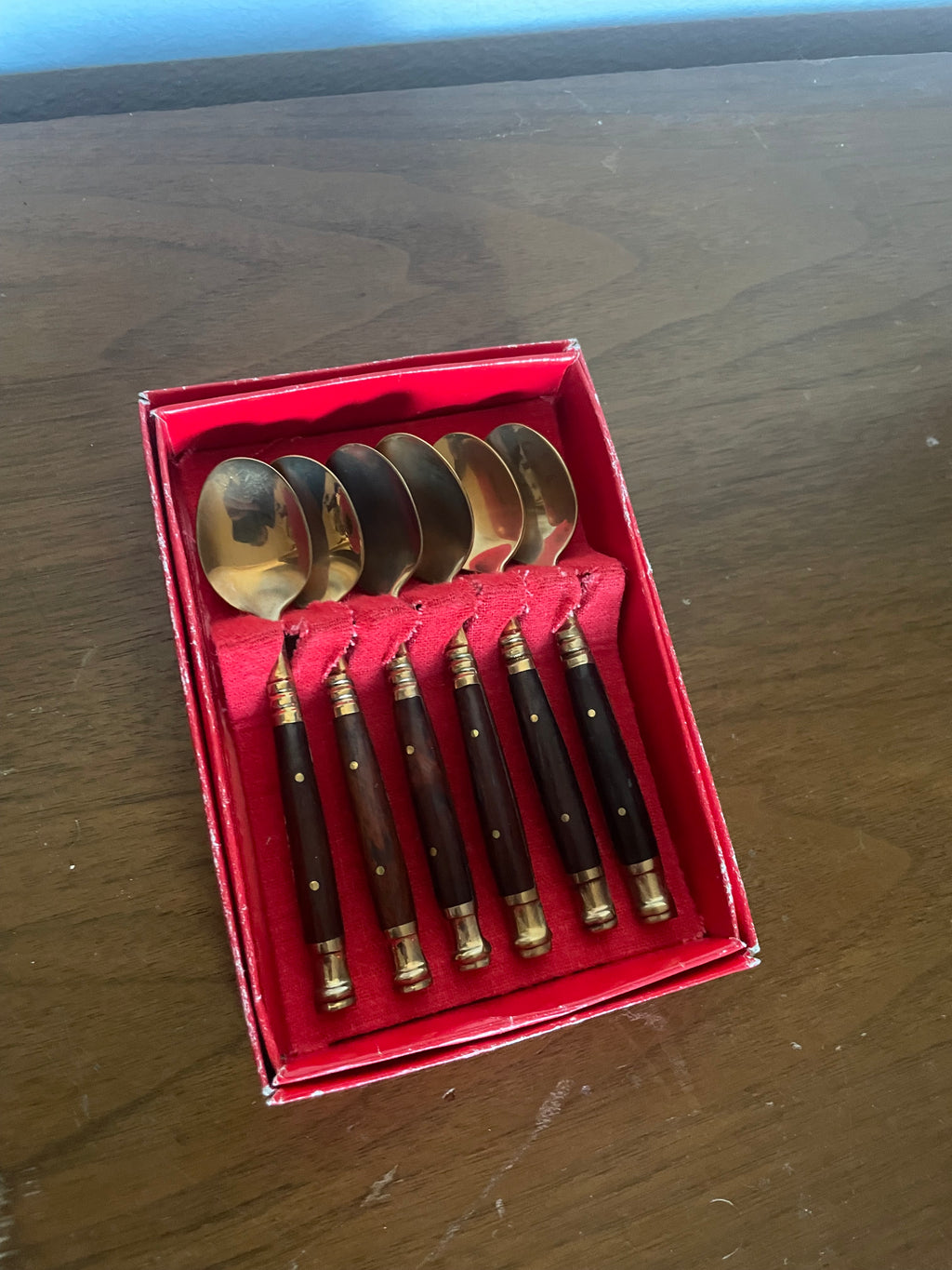 six brass and wooden tea spoons in cheap red box