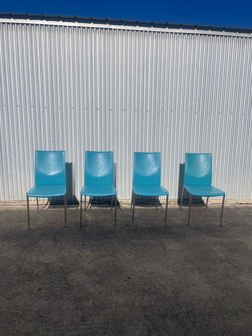set of four teal leather dining chairs