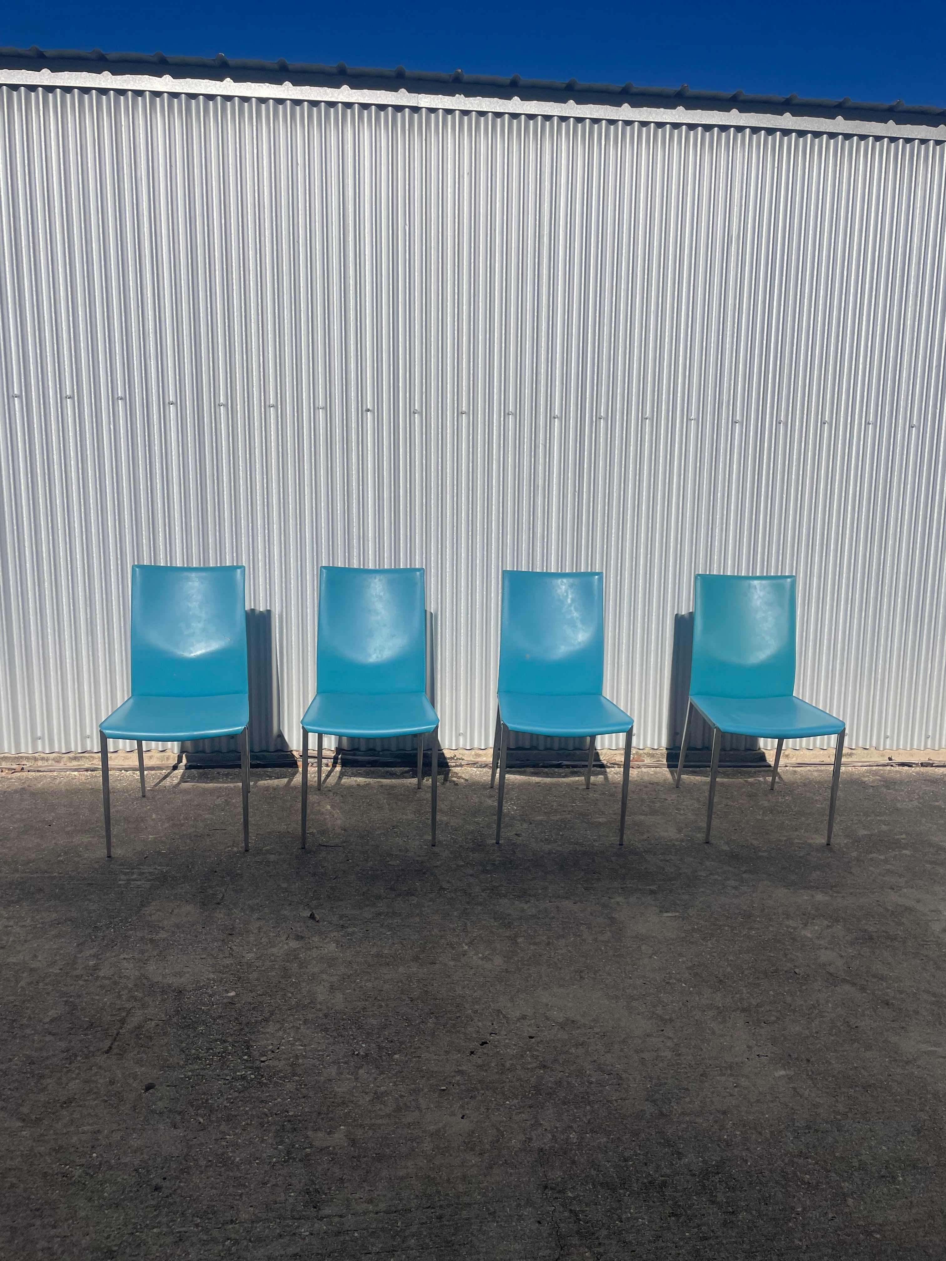 set of four teal leather dining chairs