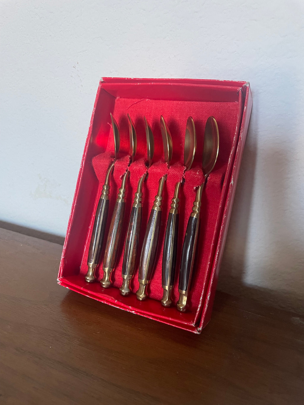 six brass and wooden tea spoons in cheap red box
